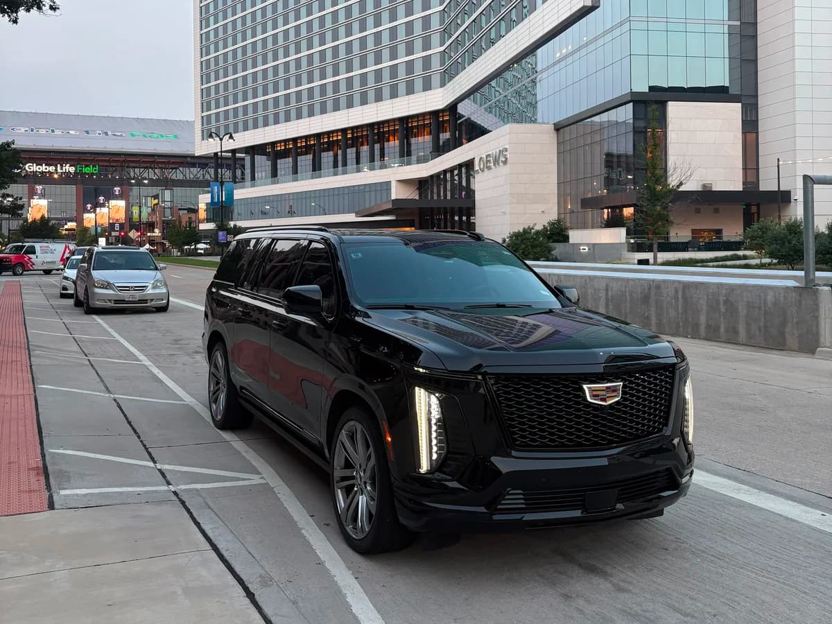 Leo Limos chauffeur and Escalade at a luxury hotel porte-cochère